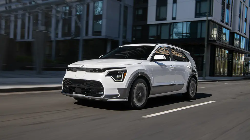 Kia-Niro-EV-City - Acceleramota A white 2023 Kia Niro EV is seen driving through the city.